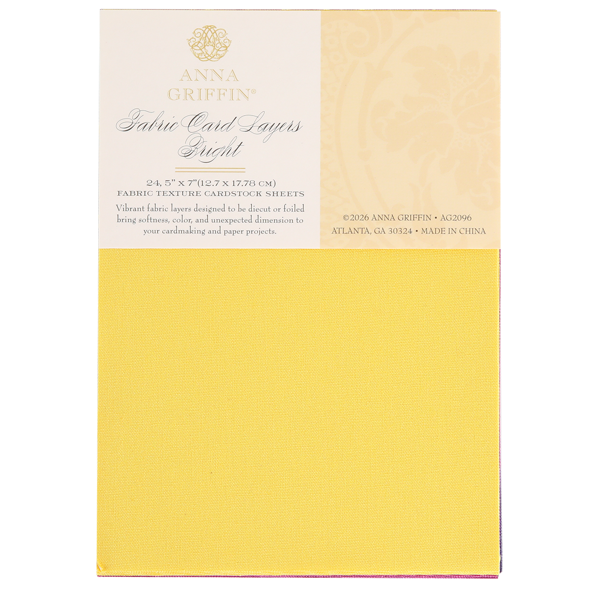A pad of Bright Fabric Card Layers by Anna Griffin in yellow, featuring textured cardstock sheets ideal for scrapbooking and card making, with product details printed on the packaging.