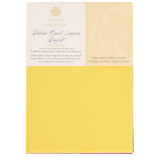 A pad of Bright Fabric Card Layers by Anna Griffin in yellow, featuring textured cardstock sheets ideal for scrapbooking and card making, with product details printed on the packaging.
