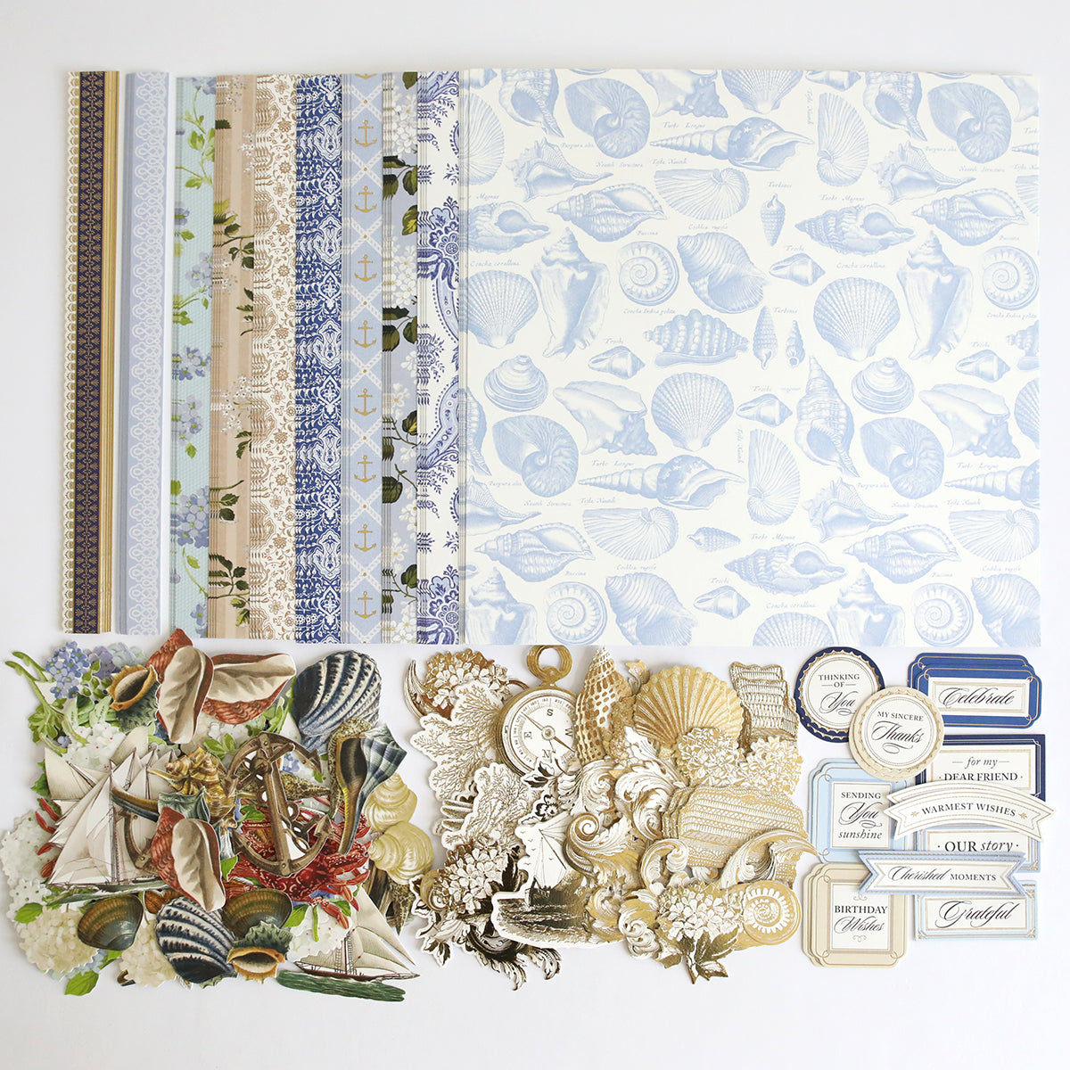 Summer House Cardstock and Embellishments featuring nautical and seashell designs, arranged on a white surface—perfect for coastal scrapbooking or nautical-themed crafts.