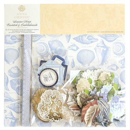 The Summer House Cardstock and Embellishments set includes blue seashell patterned paper, floral cutouts, tags, and nautical accents—ideal for coastal scrapbooking projects—all presented in attractive packaging.