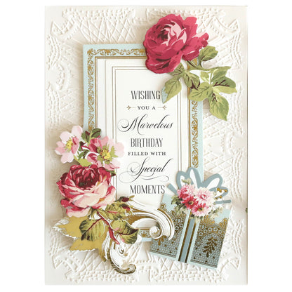 A decorative birthday card made with Luxury Ivory Soft Matte 250gsm Cardstock, featuring embossed patterns, pink and red flowers, a gold-trimmed message, and a gift illustration reading “Wishing you a marvelous birthday filled with special moments.”.