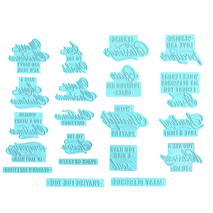 Fourteen blue plastic embossing stamps featuring reversed, cursive text for customizing messages on baked goods, arranged neatly on a white background—an ideal companion to the Gilded Small Sentiments Foil Plates Bundle or other hot foil plates for your Christmas crafting projects.