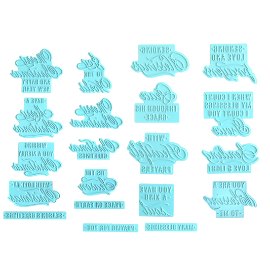 Sixteen light blue plastic cookie or fondant embossers featuring assorted inverted text designs are arranged in a grid on a white background—ideal for adding elegant messages to your baked treats or for creative Christmas card making, providing results similar to those achieved with the Gilded Small Sentiments Foil Plates Bundle.