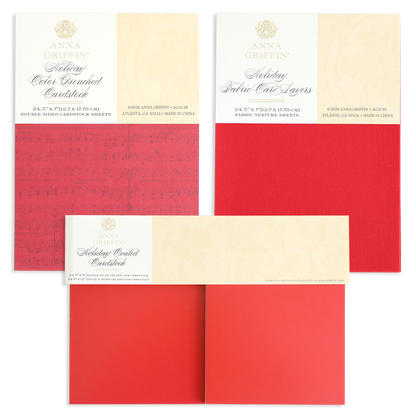 Three packs of the Holiday Cardstock Bundle by Anna Griffin, featuring textured layers in festive red shades—ideal for Christmas card making or adding cheer to your scrapbook paper crafts—are displayed flat with product labels visible at the top of each pack.
