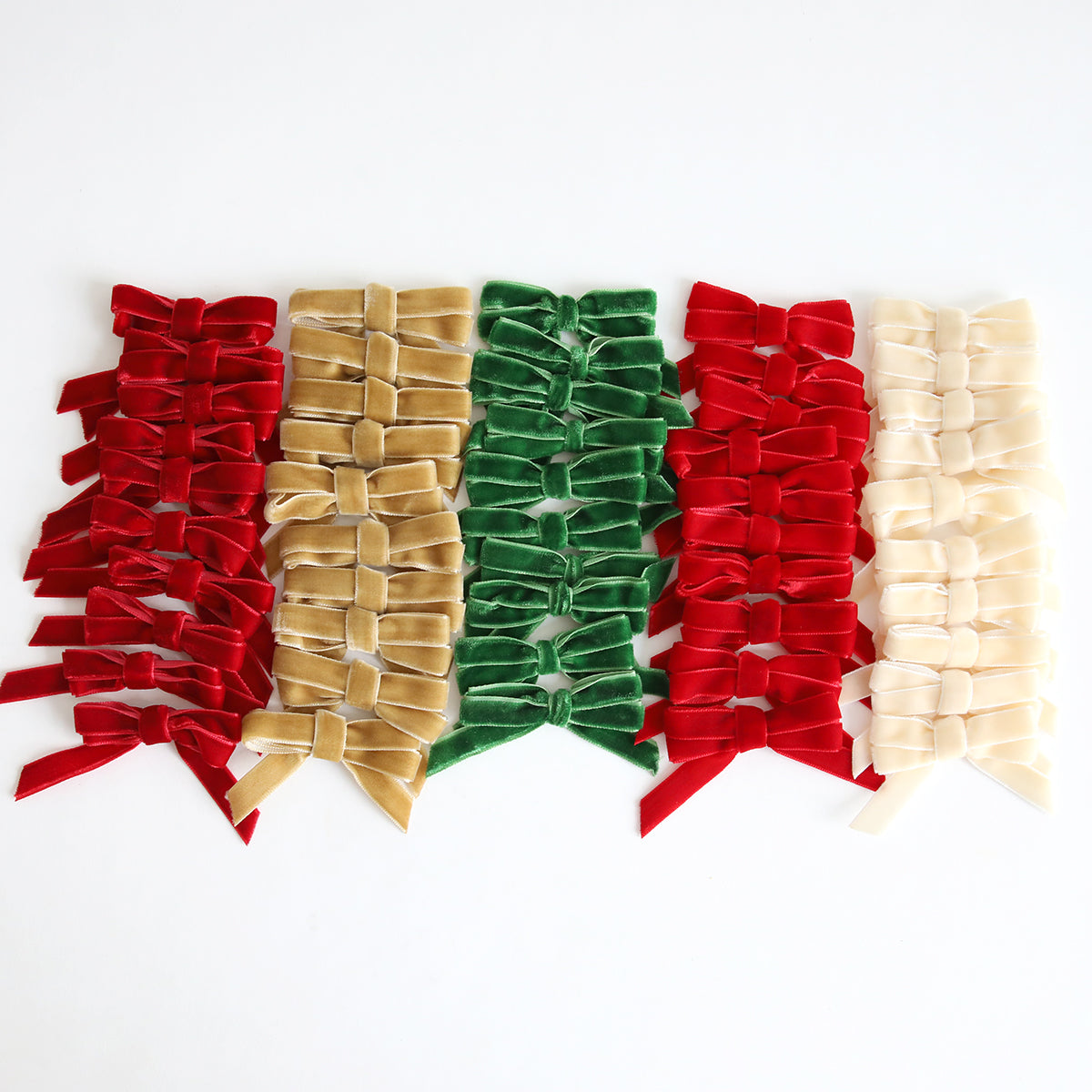 Five vertical rows of Velvet Double Bows in red, gold, green, red, and cream are arranged side by side on a white background—perfect embellishments for card making or holiday crafts.