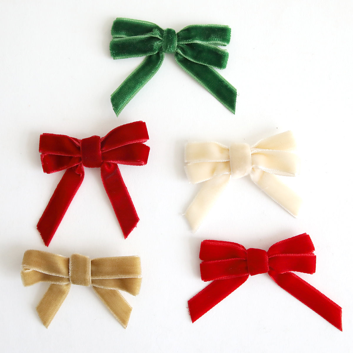 A set of five Velvet Double Bows in green, red, cream, gold, and another red color are arranged on a plain white background—an ideal choice for holiday crafts or card making.