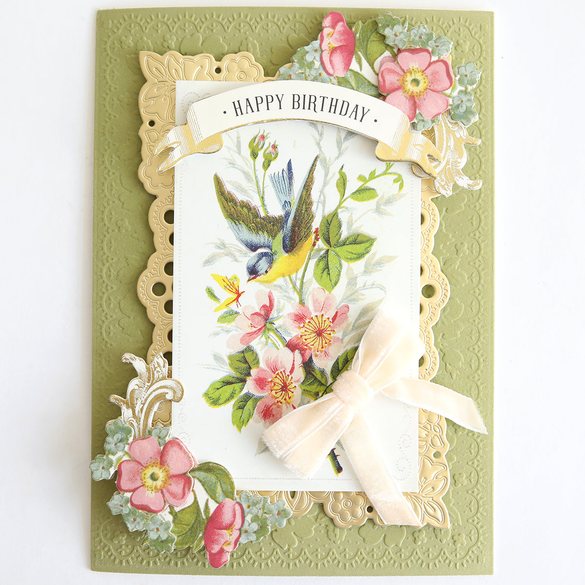 Give your next card making project a touch of inspiration with this elegant design featuring Velvet Double Bows, gold framing, delicate pink flowers, a charming bird illustration, and a beautiful floral motif. "Happy Birthday" is elegantly written at the top.