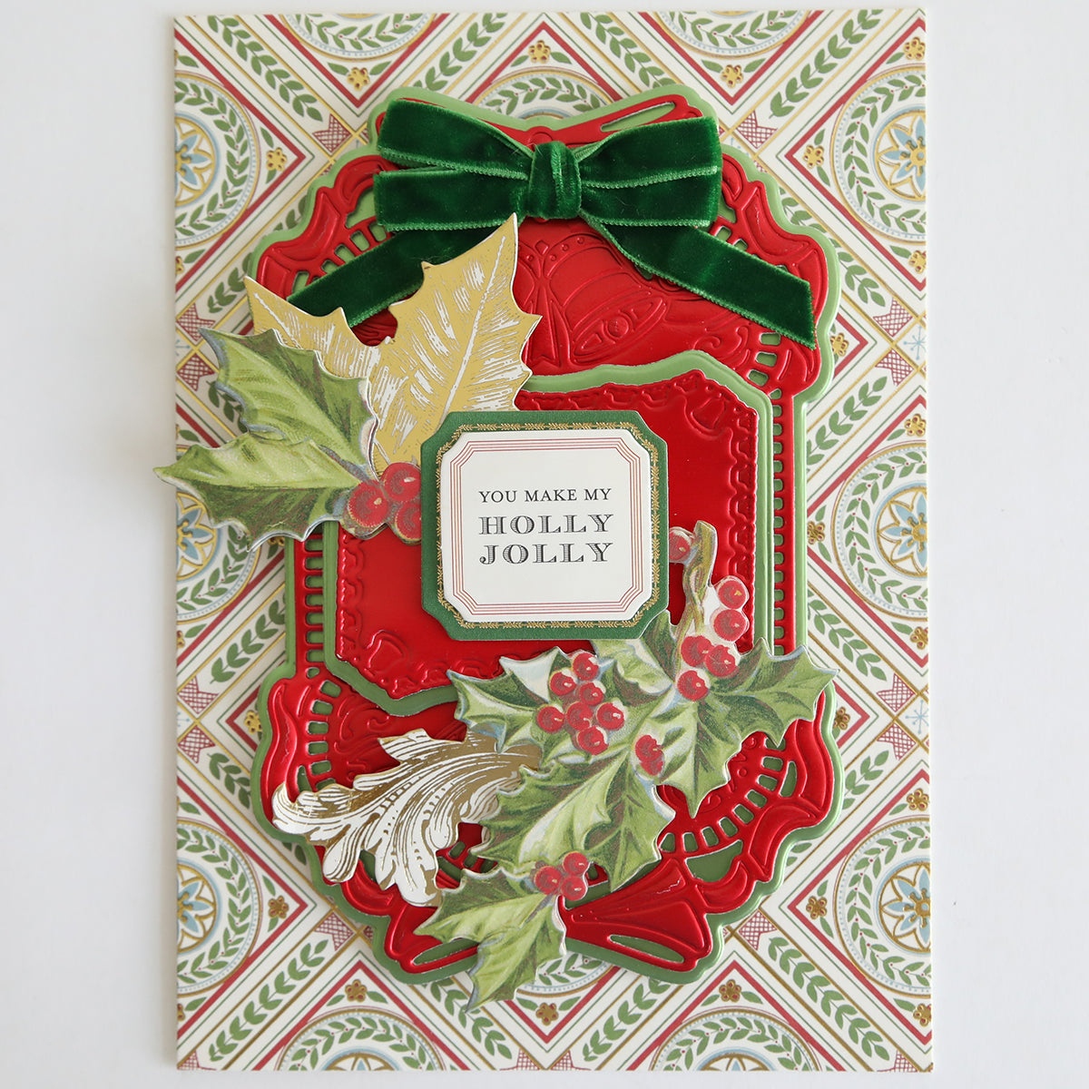 A festive holiday card adorned with Velvet Double Bows, red and gold accents, holly leaves, and berries—perfect for card making and holiday crafts—featuring the message "You make my holly jolly" in the center.