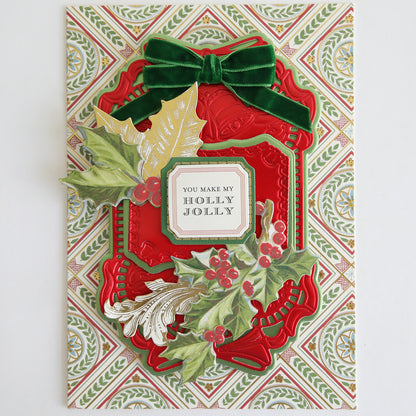 A festive holiday card adorned with Velvet Double Bows, red and gold accents, holly leaves, and berries—perfect for card making and holiday crafts—featuring the message "You make my holly jolly" in the center.