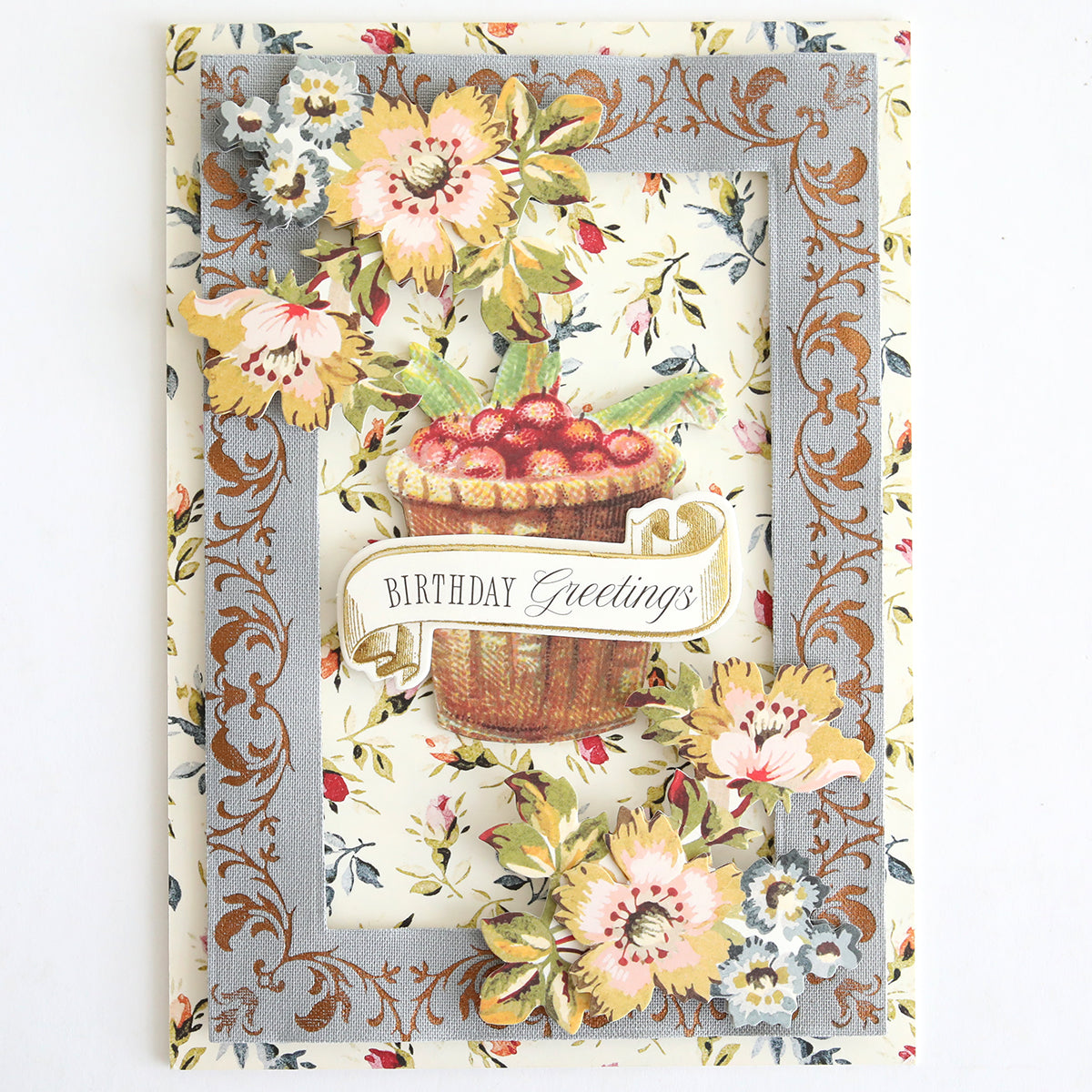 Showcasing the art of handmade cards, the Perfect Palette Fall Foil features a decorative birthday card adorned with floral patterns, 3D flowers, and a basket of cherries. The card displays the text “Birthday Greetings” and offers a charming design that is ideal for autumn paper crafting, adding a warm, seasonal touch to any celebration.