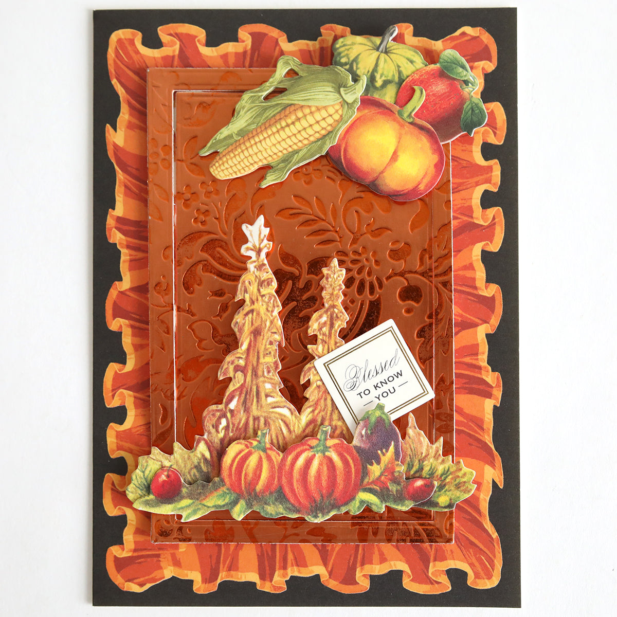 The Perfect Palette Fall Foil is a decorative autumn-themed card, ideal for autumn paper crafting and handmade cards, featuring embossed orange foil with corn, pumpkins, squash, fruit designs, and a small note that reads “Blessed to know you.”.