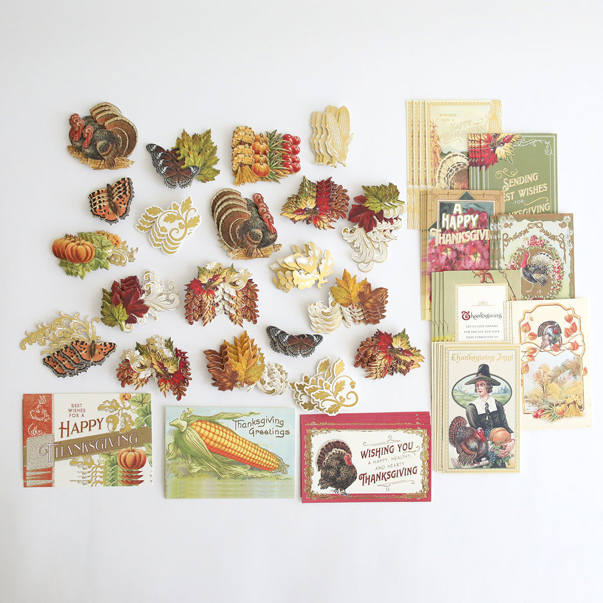 The Fall Thanksgiving Postcards and Embellishments set features vintage-style postcards, paper turkeys, pumpkins, and autumn leaves arranged on a white background for a charming collection of autumn paper crafts and fall décor.