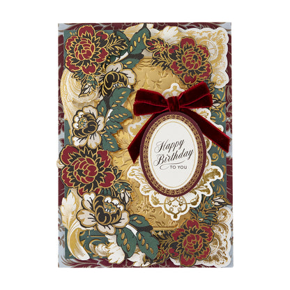 A decorative birthday card from the Venetian Ultimate Paper Crafting Collection with gold, red, and green floral designs, a red velvet bow, and cardstock embellishments.