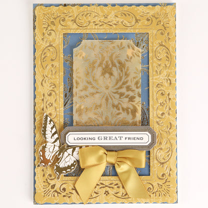 Venetian Gilded Frame Pattern Foil Plates feature an ornate gold embossed frame, damask center, yellow bow, butterfly, and “LOOKING GREAT FRIEND” label on blue.
