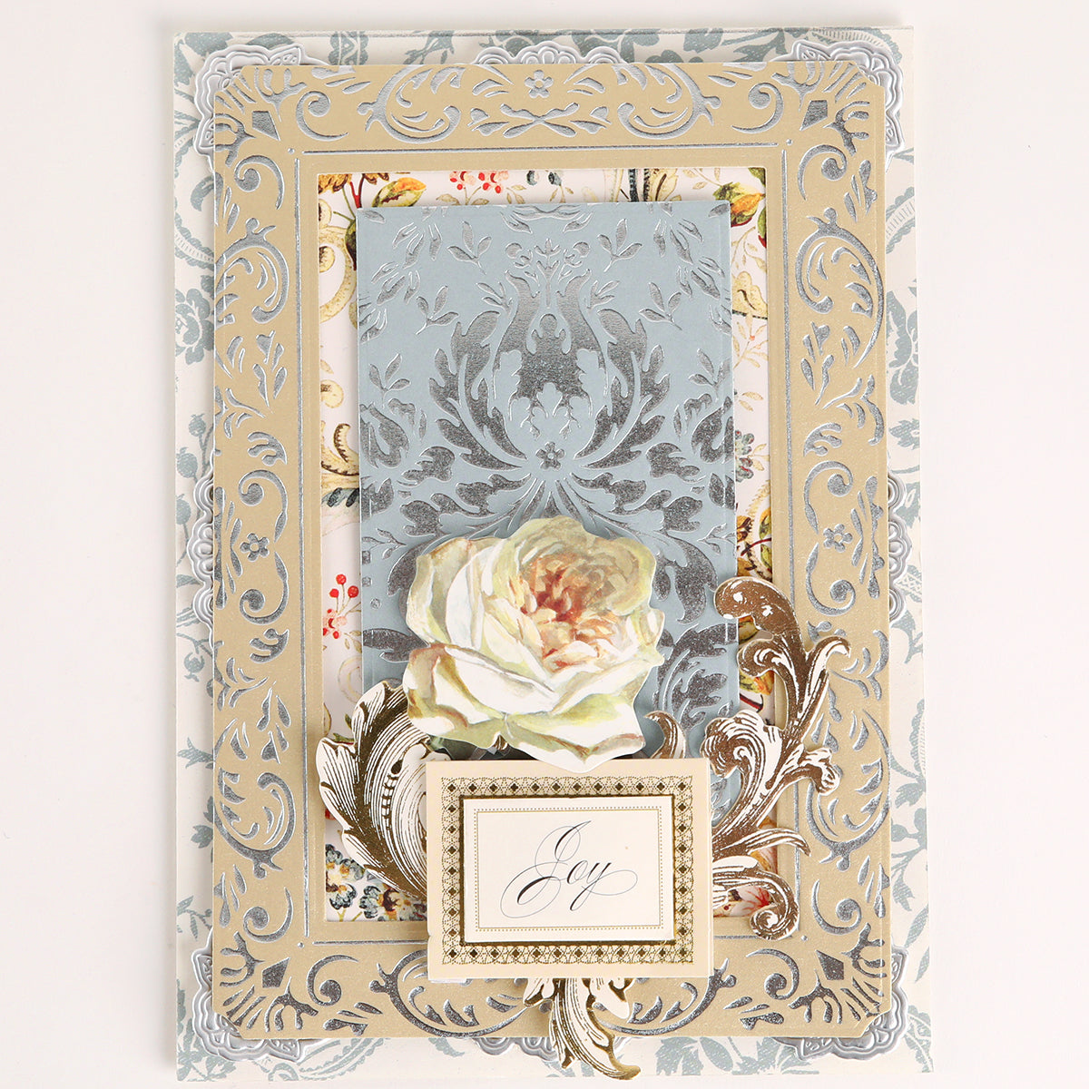Elegant card created with Venetian Gilded Frame Pattern Foil Plates, featuring layered florals, white rose, hot foil accents, and a small “joy” card in the center.