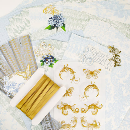 Assorted decorative paper, gold ribbon, floral die-cuts, and gold stickers featuring butterflies and scrolls are artfully arranged on a white surface—ideal for sparking creativity with the Anna Griffin | Create Fall 2026 collection in craft classes or for sharing inspiration in your creative community.
