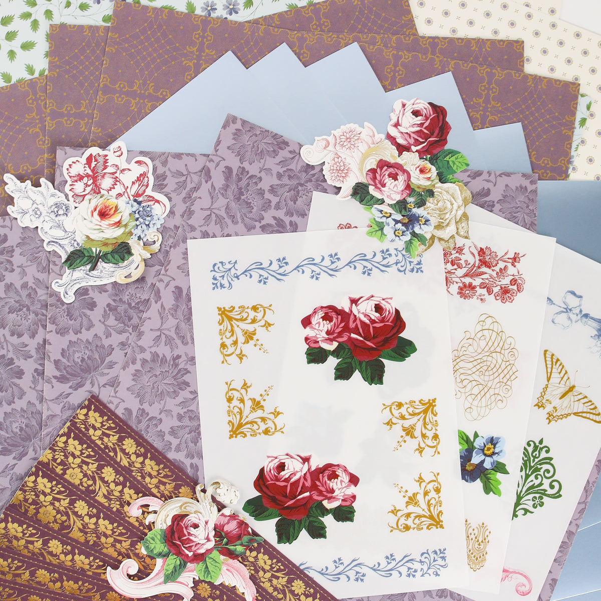 Discover the Anna Griffin | Create Fall 2026 collection—a curated assortment of decorative papers and floral stickers showcasing elegant rose designs, intricate gold patterns, and beautiful floral motifs displayed on a flat surface. Perfect for inspiring your next creative project or sharing with fellow crafters in upcoming craft classes!.