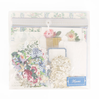 A clear plastic pouch filled with floral stickers, ornate paper cutouts, envelopes, and a blue label that reads “Home”—the Anna Griffin | Create Fall 2026 kit is perfect for heritage crafts or as an inspiring addition to your crafting classes.