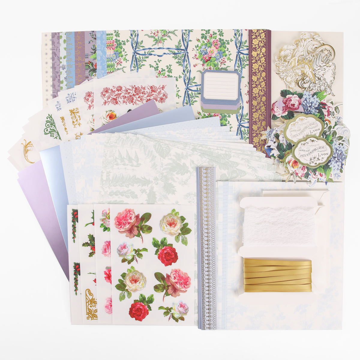 A collection of decorative papers, floral stickers, ribbons, lace, and embellishments arranged neatly on a white background—perfect for anyone inspired by heritage crafts or interested in joining Anna Griffin | Create Fall 2026 crafting classes.