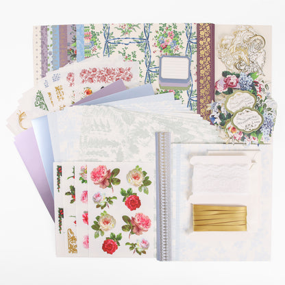A collection of decorative papers, floral stickers, ribbons, lace, and embellishments arranged neatly on a white background—perfect for anyone inspired by heritage crafts or interested in joining Anna Griffin | Create Fall 2026 crafting classes.