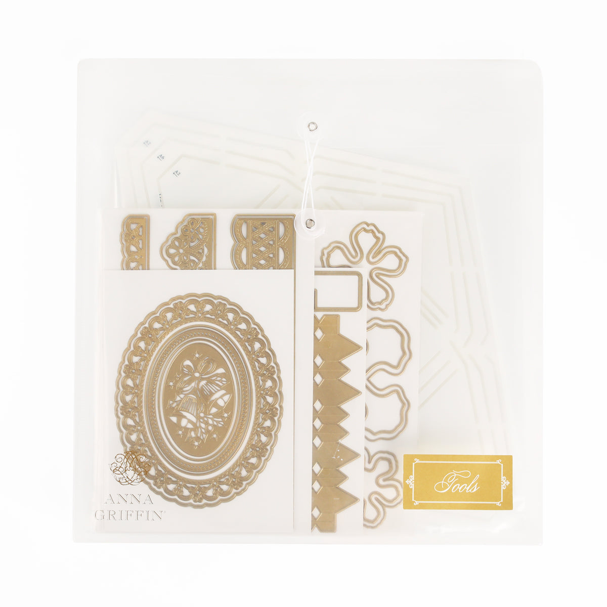 A translucent pouch holds ornate gold and white metal die cut shapes and templates for crafts, perfect for those who appreciate heritage crafts. The label reads “Anna Griffin | Create Fall 2026” and “Tools.”.