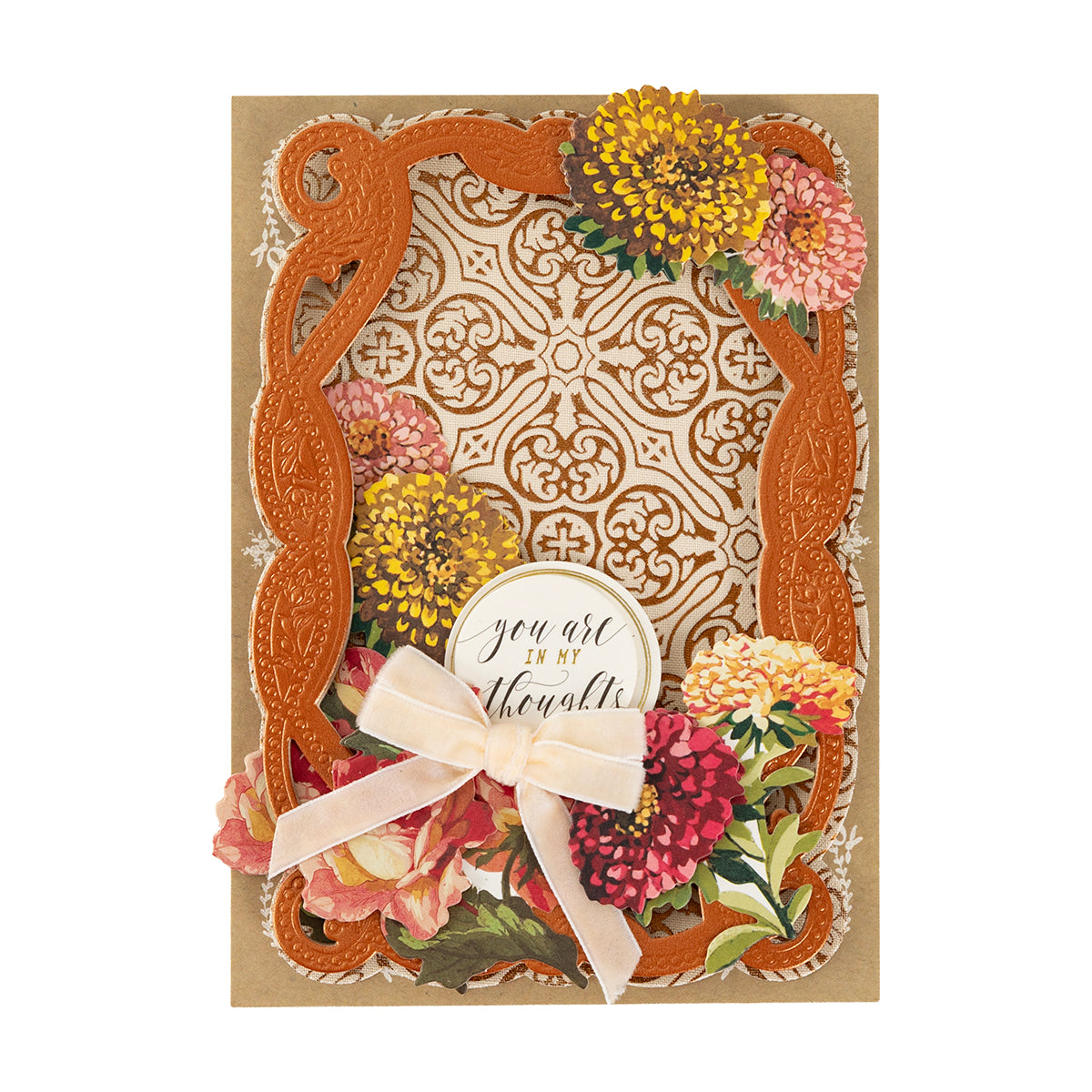 A decorative greeting card featuring Fall Flower Embellishments, an ornate orange frame, a pink bow, and a “you are in my thoughts” label on a patterned background.