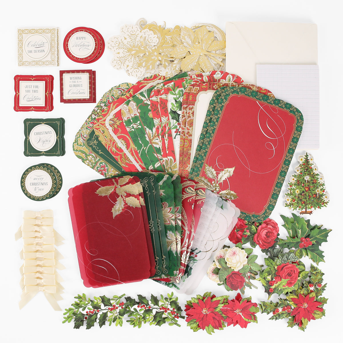 The Simply Merry Christmas Card Making Kit includes festive cards, envelopes, tags, ribbons, and floral cutouts arranged beautifully on a white surface.