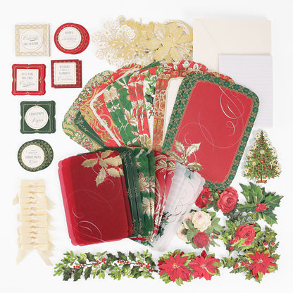 The Simply Merry Christmas Card Making Kit includes festive cards, envelopes, tags, ribbons, and floral cutouts arranged beautifully on a white surface.