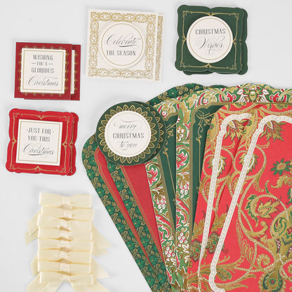 Simply Merry Christmas Card Making Kit supplies—patterned paper, greeting labels, and cream bows—arranged on a white surface.
