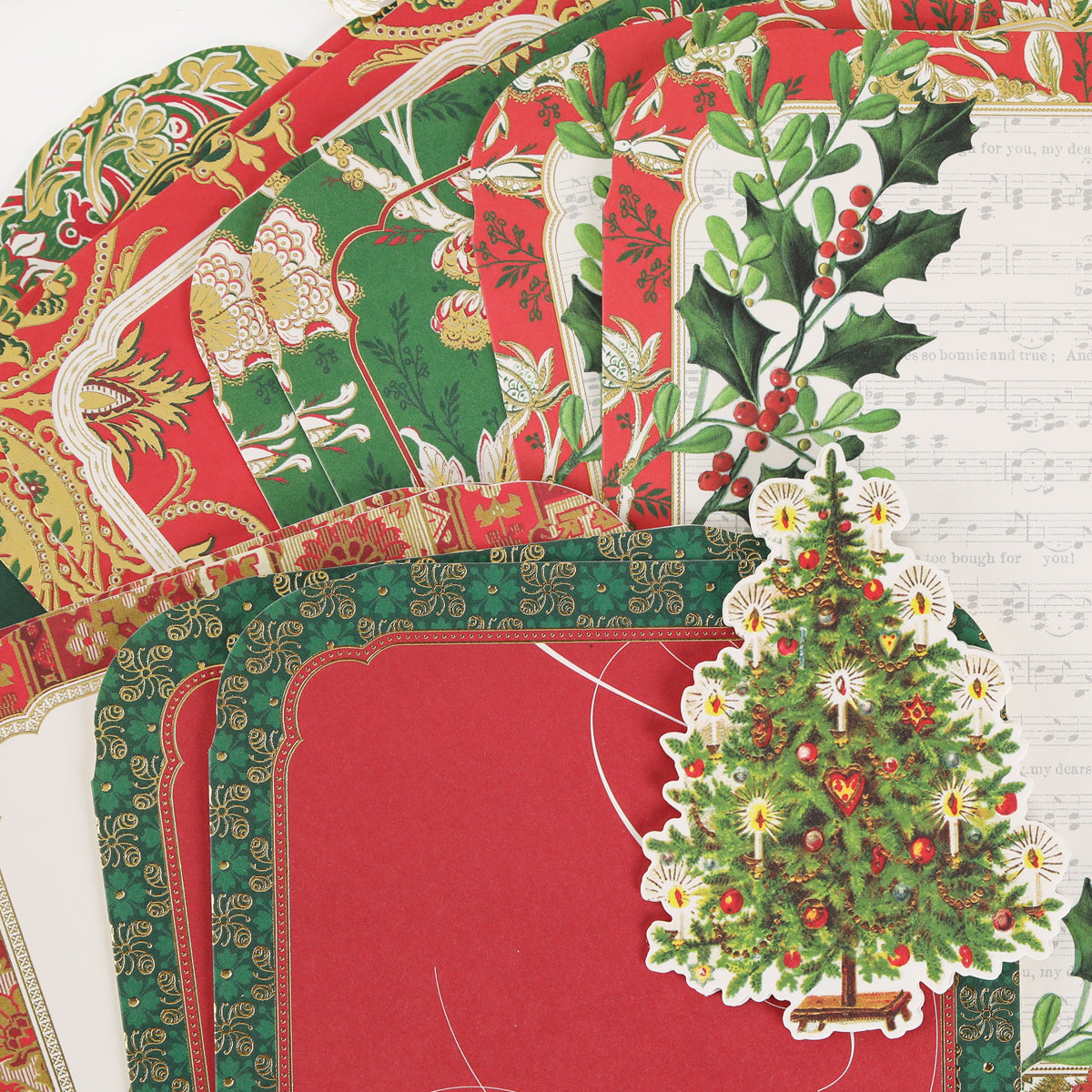 Simply Merry Christmas Card Making Kit includes holly leaf, sheet music, and Christmas tree papers—perfect for festive holiday cards.