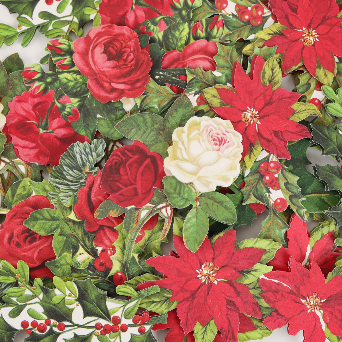 The Simply Merry Christmas Card Making Kit includes red poinsettias, red roses, a white rose, green leaves, and red berries—ideal for festive cards or holiday crafts.