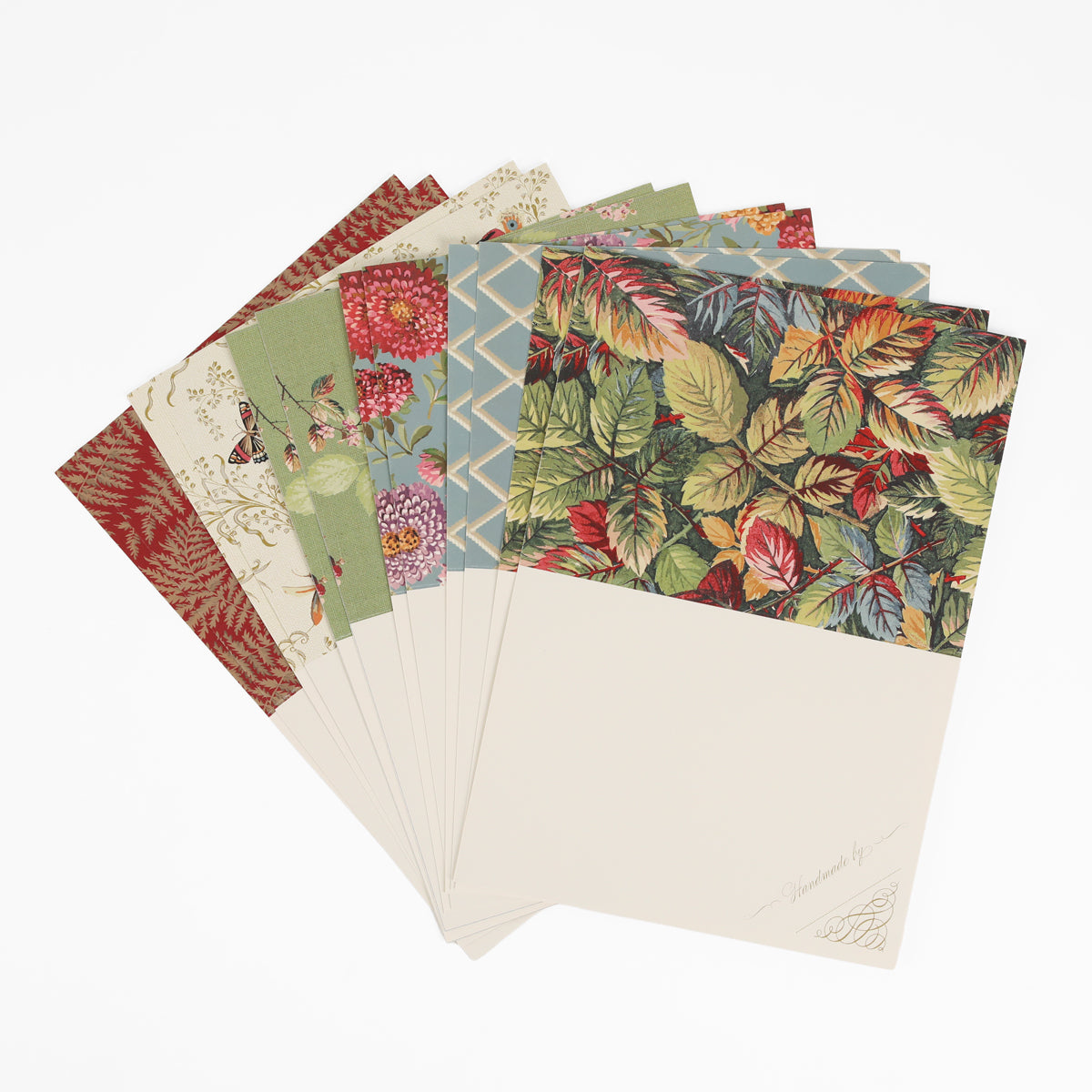 A fan arrangement of decorative stationery, featuring Sienna Folded Cards and Layers in a 5″ x 7″ size with an array of vibrant floral and geometric patterns on the top half of each card, all set against a crisp white background—perfect for cardmaking projects.