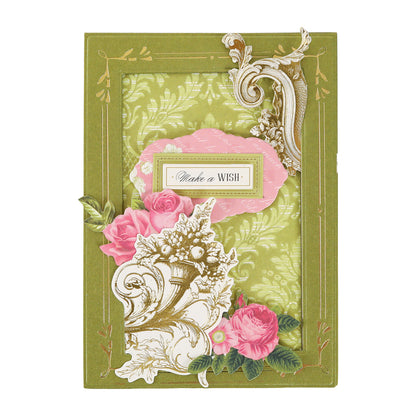 A decorative green greeting card with ornate gold details, pink flowers, and a “Make a Wish” label in the center is perfect for creative projects and can be further enhanced with Gold Foil Flourish Stickers or other scrapbook embellishments to add extra charm and elegance.