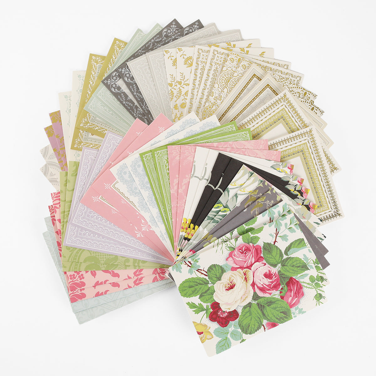 A fanned-out assortment of decorative stationery paper in various pastel and floral designs is displayed on a white surface, alongside Pretty Pattern A2 Cards and Envelopes in matching ivory, perfect for creating your own handmade greeting cards.