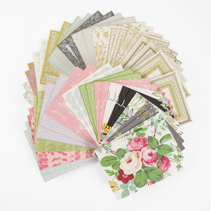 A fanned-out assortment of decorative stationery paper in various pastel and floral designs is displayed on a white surface, alongside Pretty Pattern A2 Cards and Envelopes in matching ivory, perfect for creating your own handmade greeting cards.