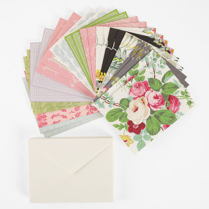 A stack of Pretty Pattern A2 Cards and Envelopes, displaying decorative floral designs, is fanned out above a single plain ivory envelope on a white background.