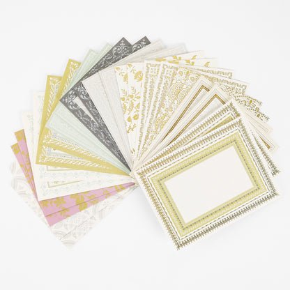 A fan-shaped arrangement of Pretty Pattern A2 Cards and Envelopes, featuring handmade greeting cards in various colors with ornate border designs, is displayed on a white background, each accompanied by a matching ivory envelope.
