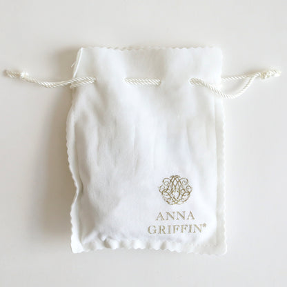 A white drawstring bag adorned with the "Anna Griffin" logo and text, ideal for keeping your Set of 2 Silver Necklaces Kit or highlighting statement necklaces and silver-tone pendants.