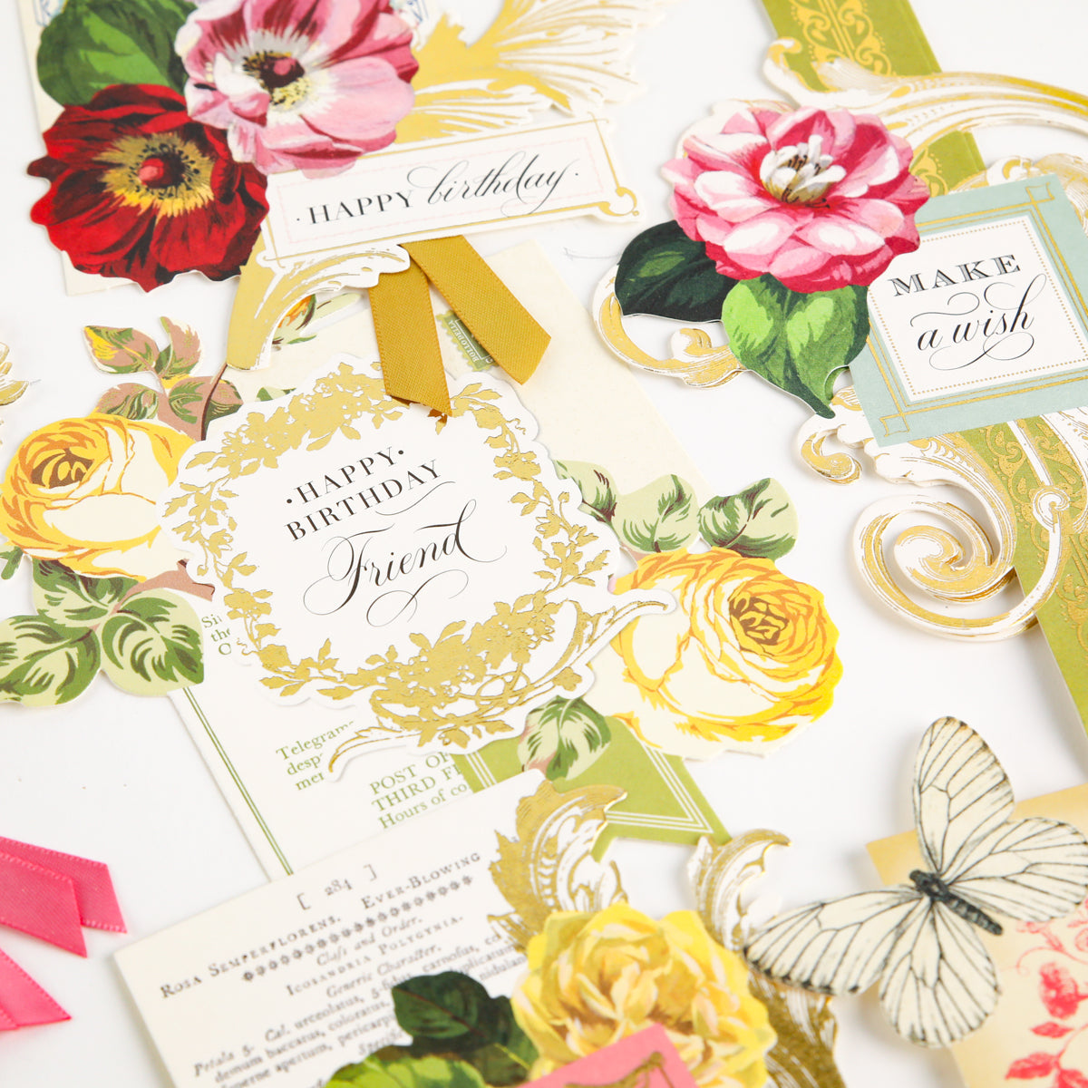 Birthday Collage Card Toppers in assorted vintage styles with floral designs, decorative text, and ribbon accents are arranged on a white surface. Each topper features vintage collage embellishments and die-cut details for a charming effect. A white butterfly illustration is also visible.