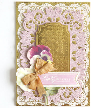 A decorative birthday card from the Shiny Foil Cardstock Bundle, Gold, featuring intricate lace designs, floral elements, and a ribbon on shiny gold cardstock. The card has the message "Birthday Wishes" elegantly displayed on a banner.