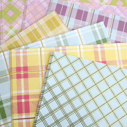 The Pastel Plaid 12x12 Cardstock showcases soft hues of yellow, green, pink, and blue in a delightful plaid pattern with shimmering gold foil accents.