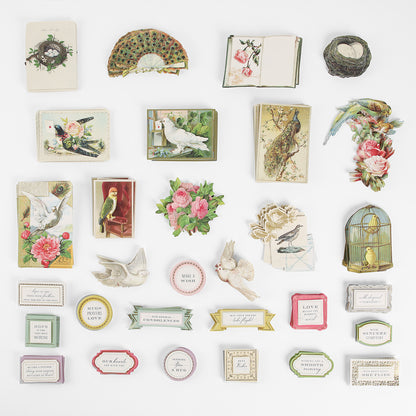 Feather Embellishments and Sentiments is a collection of vintage-style paper cutouts, including birds, flowers, books, a fan, decorative quote cards with sentiment stickers, and feather-inspired accents—all artfully arranged in a neat grid on a white background.