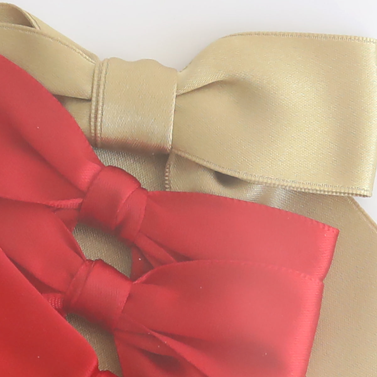 Close-up of Medium Pre-Tied Christmas Bows in gold and red satin ribbon, arranged with dark green bows on a plain white background.