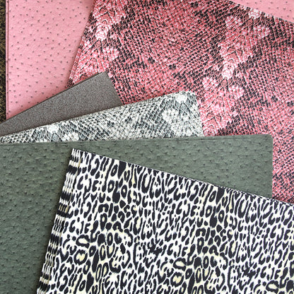 Assorted textured Animal Print 12x12 cardstocks with glitter for papercraft projects on a pink background.