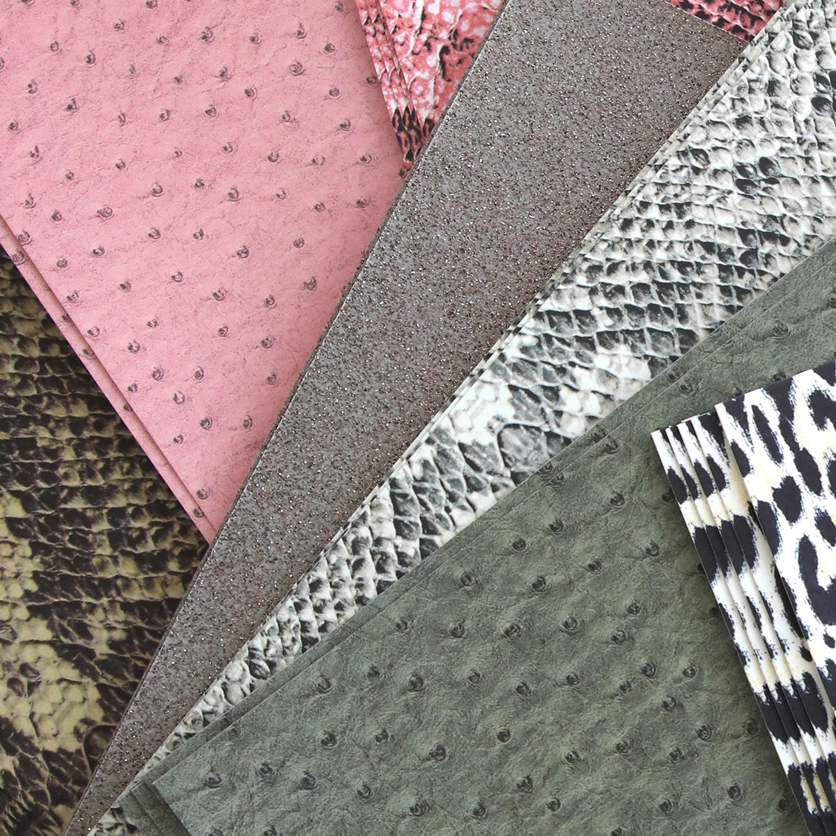 An assortment of textured fabric and Animal Print 12x12 Cardstock samples in various patterns and colors.