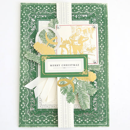 Celebrate the season with this green and cream handmade Christmas card, embellished with layered paper designs, leafy accents, ribbon details, and a central “Merry Christmas” greeting. Featuring an elegant vintage illustration of a man in gold and white, the card is adorned with Christmas Engravings Collage Card Toppers for a beautifully charming holiday touch.