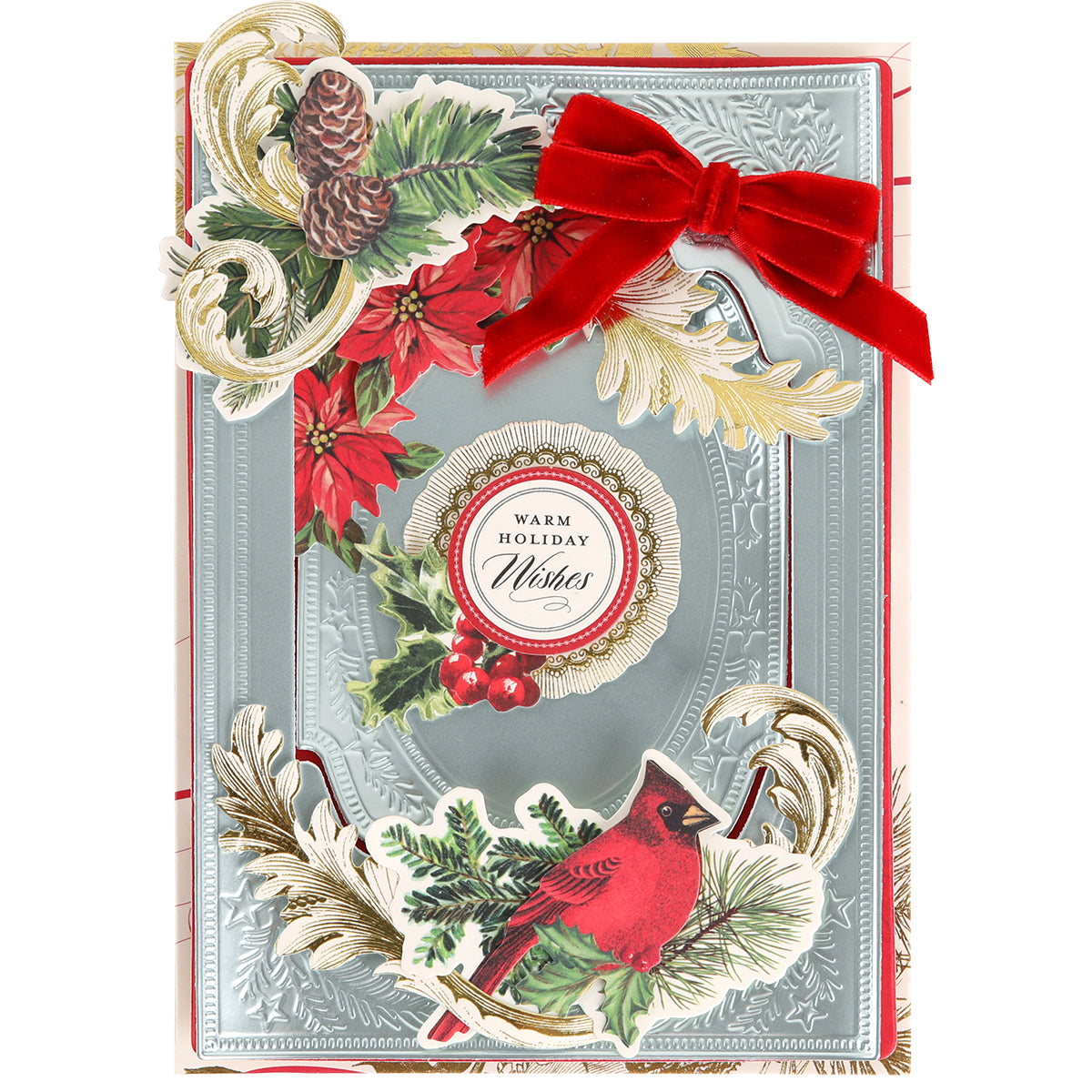 Holiday card crafted from Ice Blue Foil Cardstock Bundle, featuring a metallic silver border and adorned with a red velvet bow, poinsettias, pinecones, holly, and a cardinal. The center displays the text "Warm Holiday Wishes.