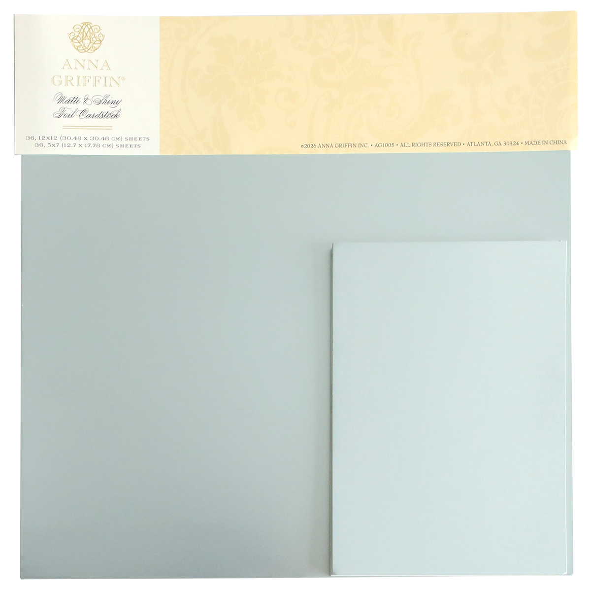 A set of Ice Blue Foil Cardstock Bundle sheets by Anna Griffin, displayed in their original packaging with a decorative beige label at the top. This collection includes both shiny foil and matte cardstock finishes, making it perfect for enhancing your creative projects.