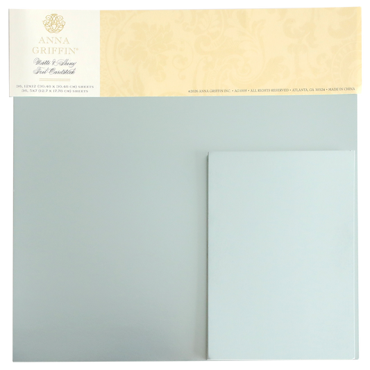 A set of Ice Blue Foil Cardstock Bundle sheets by Anna Griffin, displayed in their original packaging with a decorative beige label at the top. This collection includes both shiny foil and matte cardstock finishes, making it perfect for enhancing your creative projects.