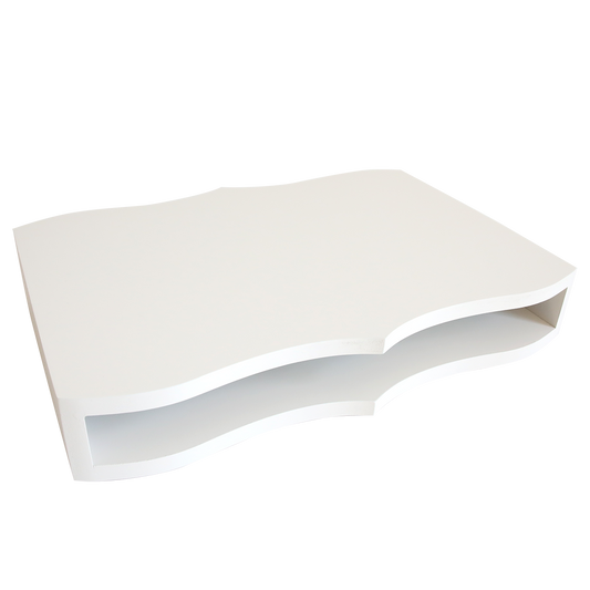 The Empress Lazy Susan is a white, rectangular table with wavy edges and an open shelf for plate storage beneath the tabletop, displayed against a plain white background.